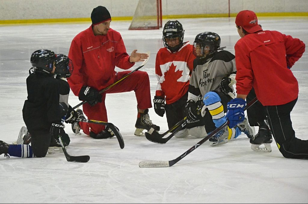Hockey coach teaching kids